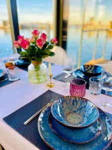 a table with blue plates and a vase of flowers at Hausboot inkl Motorboot, Ostsee in Heiligenhafen