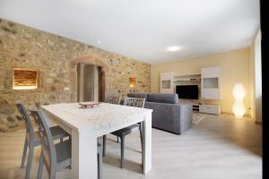 a kitchen and living room with a white table and chairs at Casa Vera Aurora Lake Garda in Torri del Benaco