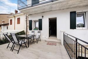 a patio with a table and chairs on a balcony at Casa Vera Aurora Lake Garda in Torri del Benaco