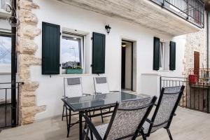 a table and chairs on a balcony with green shutters at Casa Vera Aurora Lake Garda in Torri del Benaco