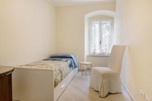 a bedroom with a bed and a chair and a window at Casa Vera Aurora Lake Garda in Torri del Benaco