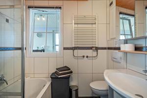 a bathroom with a sink and a tub and a toilet at Chilli Home in Tettnang