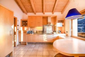 a kitchen with a table and a blue lamp at La Pratolina Attico in Castello di Fiemme +28 photos