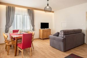 a living room with a couch and a table with a chair at Ciasa De Marugiana in Gardeccia - San Giovanni di Fassa