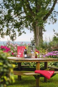 una mesa de picnic con una botella de vino y flores en Berghotel Hohe Mark en Reken
