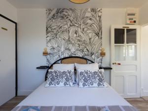 a bedroom with a white bed with two pillows at Petite Maison Cosy in Trégastel