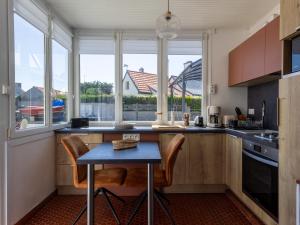 a kitchen with a table and some windows at Petite Maison Cosy in Trégastel +16 photos