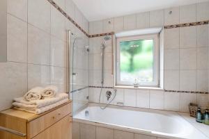 a white bathroom with a tub and a window at Bei Annemarie in Trier +35 photos