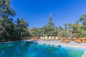 a swimming pool with tables and chairs next to it at Espacio Rural La Cabaña de Miraflores in Miraflores de la Sierra