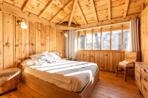 a bedroom with a bed in a wooden room at Villa Bayani Été in Lacanau
