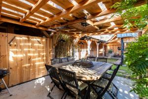a patio with a wooden table and chairs at Villa Bayani Été in Lacanau +21 photos