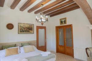 a bedroom with a bed and a chandelier at Espacio Rural La Cabaña de Miraflores in Miraflores de la Sierra +37 photos