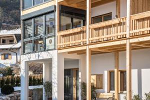 a house in the mountains with a wooden deck at Apt Fichte - Nockerhof in Andrian +10 photos
