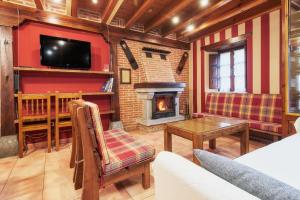 a living room with a fireplace and a tv at El Serenal in Santa Maria de Valdeón