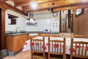 a kitchen with a table and chairs and a sink at El Serenal in Santa Maria de Valdeón