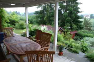 a patio with a table and chairs on a porch at Haus Elke in Gomadingen