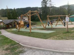 a playground with wooden swings and a sidewalk at Cosy 4p, Pied des Pistes, Pra Loup in Uvernet