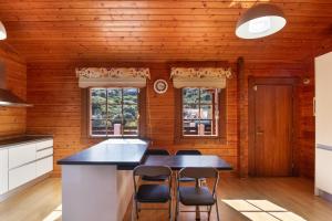 a kitchen with wooden walls and a large island with chairs at Villa Tanqueta in Santa Brígida