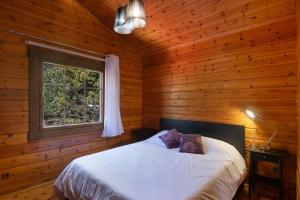 a bedroom with a bed in a log cabin at Villa Tanqueta in Santa Brígida +25 photos