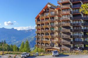 a tall building with cars parked in front of it at Cosy 4p, Pied des Pistes, Pra Loup in Uvernet