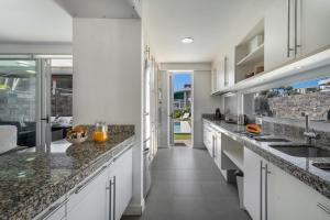 a kitchen with white cabinets and granite counter tops at Villa Playa del Duque in Adeje
