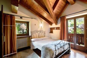 a bedroom with a bed in a room with windows at Pelòt-de la Masse in Aosta