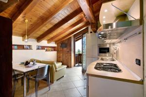 a kitchen with a stove and a table in a room at Pelòt-de la Masse in Aosta