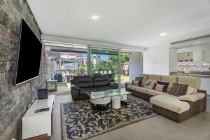 a living room with a couch and a tv at Villa Playa del Duque in Adeje