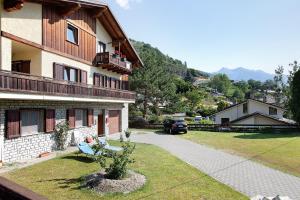 a house with a bench in the grass next to a driveway at Pelòt-de la Masse in Aosta