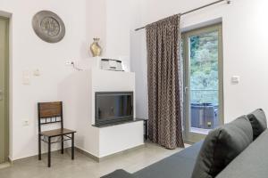 a living room with a tv and a window at Menagia Village in Agios Georgios