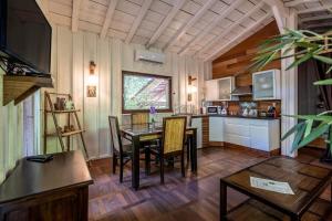 a kitchen and dining room with a table and chairs at Chalet Savannaketh in Lacanau +14 photos