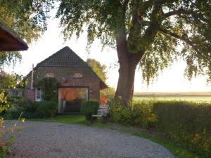 a brick house with a tree and a bench at Feriencottage Nordseeluft in Siekbüll