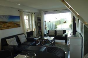 a living room with a couch and chairs and a window at Feriencottage Nordseeluft in Siekbüll