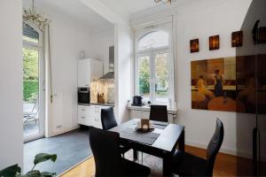 a kitchen with a table and chairs in a room at Villa am Weinberg in Wiesbaden