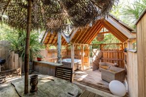 a wooden house with a wooden floor and a patio at Chalet Savannaketh in Lacanau