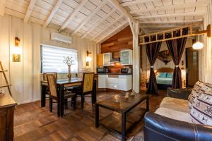 a living room with a dining room table and a couch at Chalet Savannaketh in Lacanau
