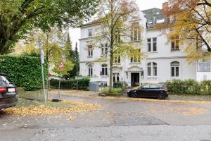 a black car parked in front of a white house at Villa am Weinberg in Wiesbaden
