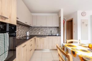 a kitchen with wooden cabinets and a table with a table cloth at Night and day 3 in Predazzo