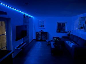 a blue room with a couch and a tv at Bergisch Resort Josef in Lindlar