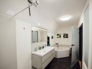 a white bathroom with a sink and a mirror at Die Gönothek - Ferienwohnungen in Iphofen +50 photos