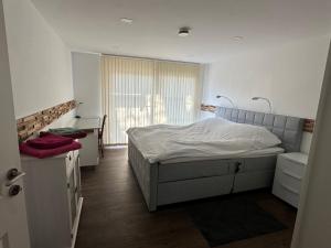 a bedroom with a bed and a desk and a window at Bergisch Resort Josef in Lindlar