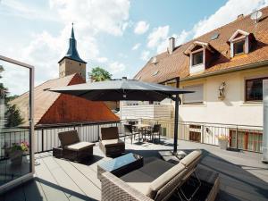 a patio with an umbrella and chairs and a table at Die Gönothek - Ferienwohnungen in Iphofen