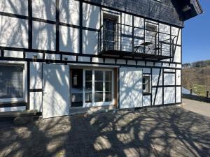 an exterior view of a white house with a balcony at Bergisch Resort Josef in Lindlar