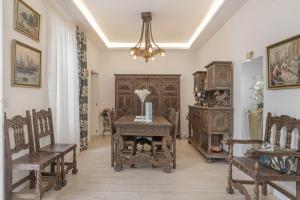 a room with a table and chairs and a chandelier at Barsanz Palace Home in Alcalá del Valle