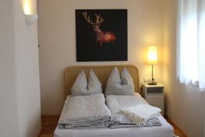 a bed with white pillows and a picture of a deer at Lautertal Zinne in Hayingen