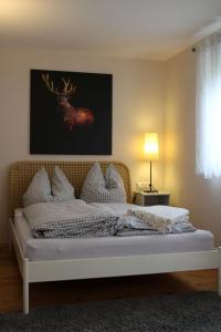 a bedroom with a bed with a deer painting on the wall at Lautertal Zinne in Hayingen
