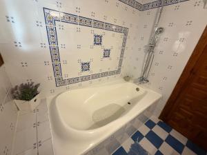 a bath tub in a bathroom with a tile wall at Casa Trinidad in Denia +28 photos