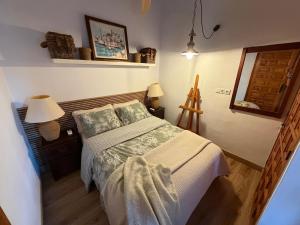 a bedroom with a bed and two lamps and a mirror at Casa Trinidad in Denia