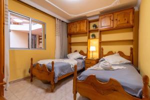 two beds in a room with a window at Costamar Arinaga in Arinaga