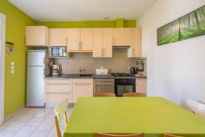 a kitchen with a table and a green table and chairs at Maison Individuelle, Royan Centre in Royan +13 photos
